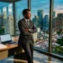 Homme en costume noir dans bureau moderne avec vue panoramique urbaine