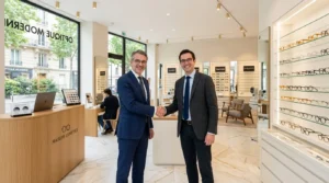 Deux hommes en costume se serrent la main dans un magasin d'optique moderne.