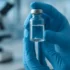 Chercheur manipulant un flacon dans un laboratoire pharmaceutique moderne